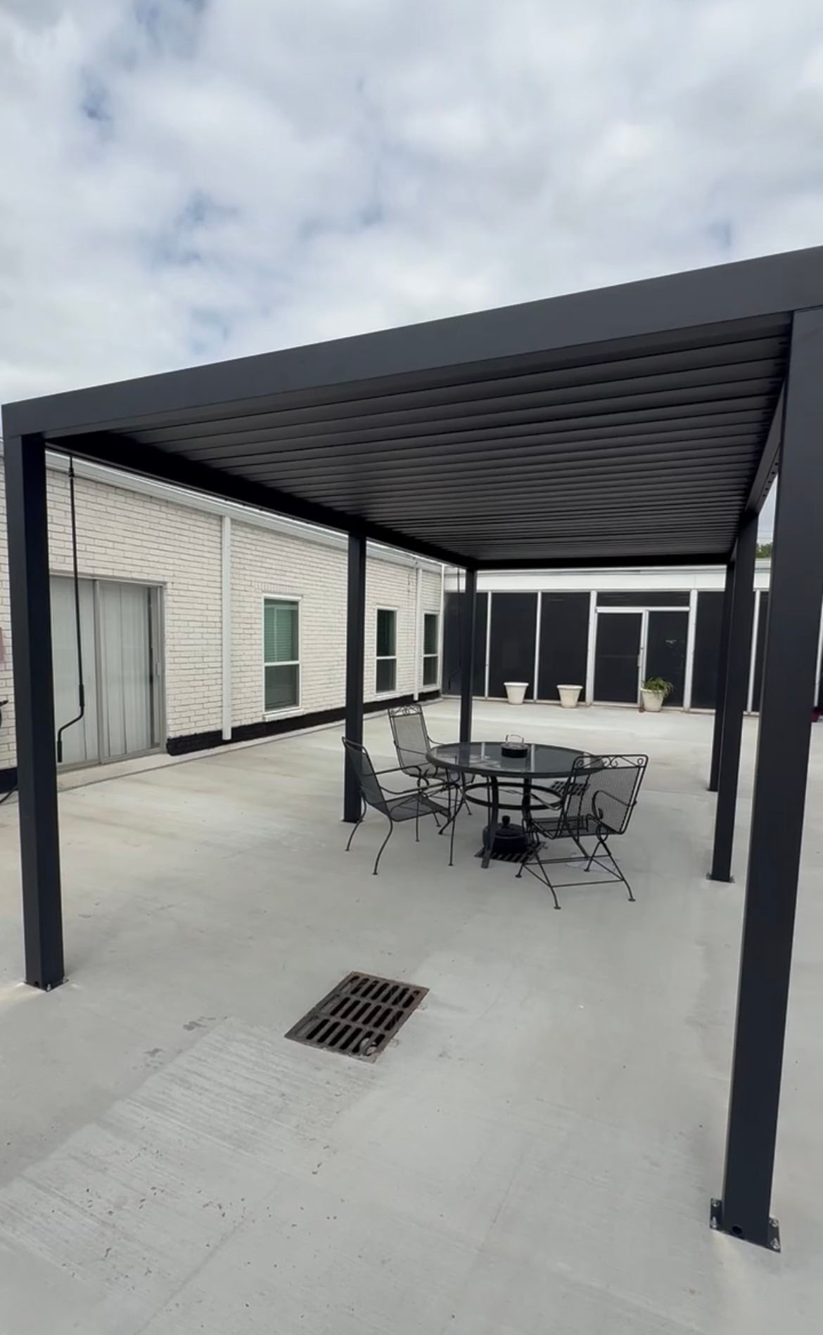 Modern black metal pergola patio cover over concrete courtyard